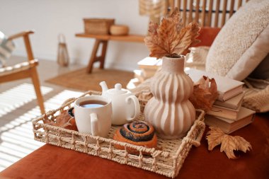 Sıcak çay tepsisi, lezzetli haşhaşlı çörekler ve evdeki kanepede çaydanlık, yakın çekim.