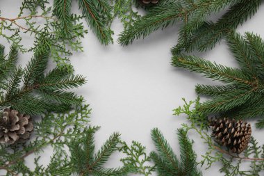 Gri arkaplanda Noel dallarından yapılmış bir çerçeve. Üst görünüm