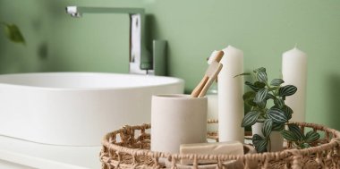 Diş fırçası, mum ve sabun banyoda lavabonun yanında.