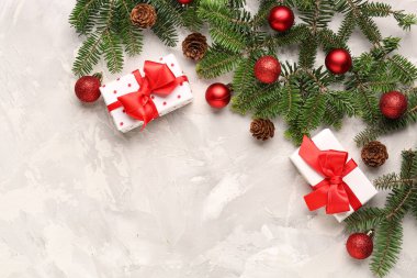 Beyaz grunge arka planında hediye kutuları ve topları olan Noel ağacı dalları