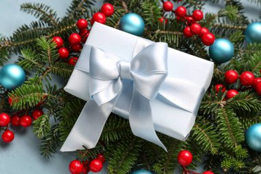 Toplu Noel ağacı dalları, rowan ve mavi arka planda hediye kutusu