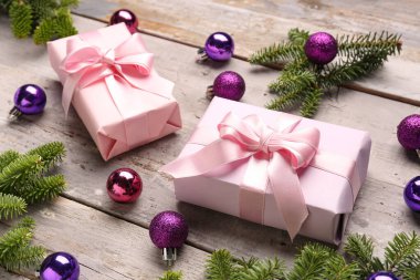 Yılbaşı ağacı dalları taşaklı ve hediye kutuları gri ahşap arka planda