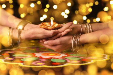 Diwali için el feneri tutan Hintli kadınların elleri (Işık Festivali) koyu arkaplanda