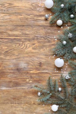 Tahta arka planda topları ve konfetisi olan Noel ağacı dalları