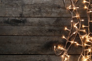 Koyu ahşap arka planda parlayan Noel ışıkları