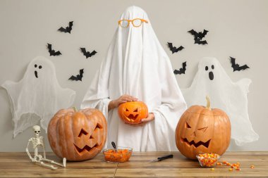 Ahşap masada oyulmuş Cadılar Bayramı balkabakları olan hayalet.