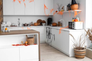 Cadılar Bayramı için beyaz tezgahlarla dekore edilmiş aydınlık mutfak.