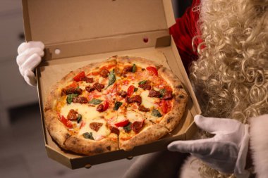 Noel arifesinde evde lezzetli pizzalı Noel Baba, yakın plan.