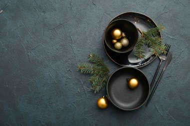 Noel baloları ve koyu arkaplanda köknar dalları olan güzel bir masa.