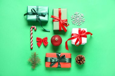 Yeşil arka planda hediye kutuları ve süslemeleri olan güzel bir Noel kompozisyonu