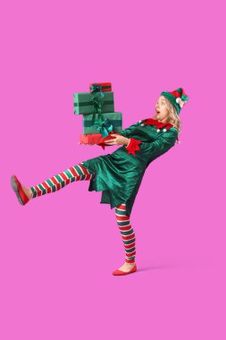 Mor arka planda Noel hediyeleriyle elf gibi giyinmiş genç bir kadın şok oldu.