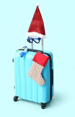 Şnorkel maskeli bavul, Noel Baba şapkası ve arka planda Noel çorabı.