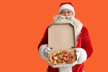 Noel Baba turuncu arka planda bir kutu lezzetli pizzayla