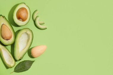 Yeşil arka planda taze avokado ve yaprak kes