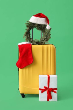 Noel çelengi, Noel Baba şapkası, çorap ve hediye yeşil arka planda.