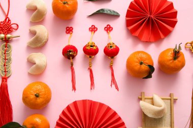 Kağıt yelpaze, mandalina ve pembe arka planda Çin sembolleri olan kompozisyon. Yeni yıl kutlaması