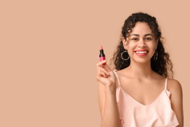 Kahverengi arka planda pembe ruju olan güzel bir Afro-Amerikalı kadın.