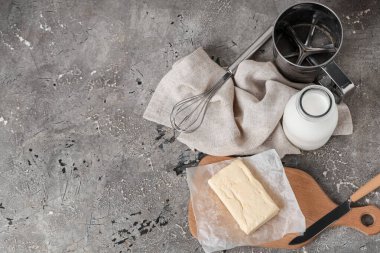 Grunge arka planında tereyağı, süt ve mutfak gereçleri ile kompozisyon