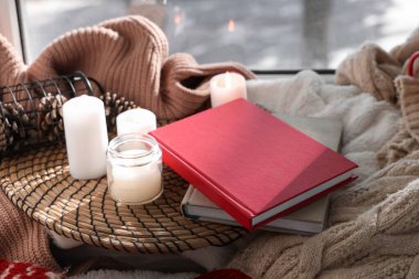 Kitapları, kış süslemeleri ve pencere kenarında kalın giysileri olan güzel kompozisyon.