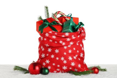 Noel Baba çantası hediye kutuları, Noel baloları, şeker kamışı ve beyaz arka planda köknar dalları