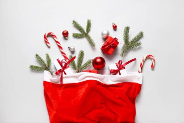 Noel kutulu Noel Baba çantası, hediye kutuları, baston şekerler ve gri arka planda köknar dalları