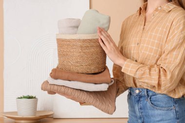 Hasır sepeti ve temiz giysileri olan genç bir kadın.