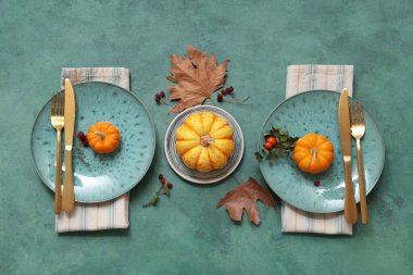 Taze balkabakları, gül kalçası böğürtlenleri ve yeşil arka planda sonbahar yapraklarıyla güzel bir masa.