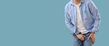 Mavi arka planda prostat sorunu olan genç bir adam ve mesaj için yeri var. Prostat kanseri farkındalığı