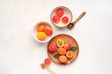 Beyaz arka planda tatlı kayısılar ve tabaklar