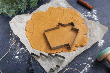 Ham hamurlar ve kesiciler karanlık arka planda tatlı Noel kurabiyeleri hazırlamak için