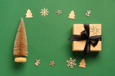 Hediye kutusundan yapılmış çerçeve ve yeşil arka planda Noel süslemeleri