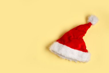 Açık sarı arka planda Noel Baba şapkası