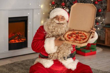 Noel arifesinde evde oturan lezzetli pizzalı Noel Baba
