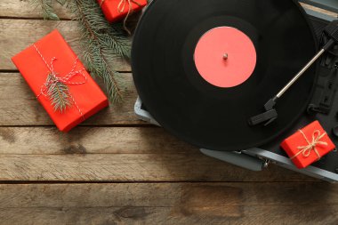 Noel süslemeleri ve ahşap arka planda hediyeleri olan klasik turntable.