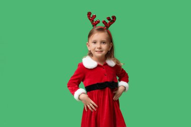 Yeşil arka planda Noel Baba kostümlü şirin küçük kız.