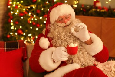 Noel Baba, Noel arifesinde evde lokumla sıcak çikolata içiyor.