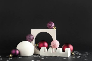 Decorative stands with different Christmas balls and confetti on black background clipart