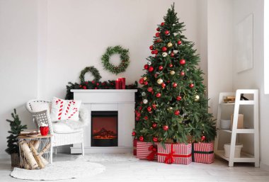 Işıl ışıl bir oturma odası şöminesi ve güzel bir Noel ağacı var.