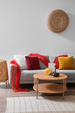 Gri kanepeli şenlikli oturma odası, kahve masasında çaydanlık ve Çin Yeni Yıl kutlamaları için dekorasyon.