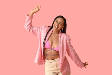 Pembe arka planda örgüleri olan seksi Afro-Amerikan kadın.