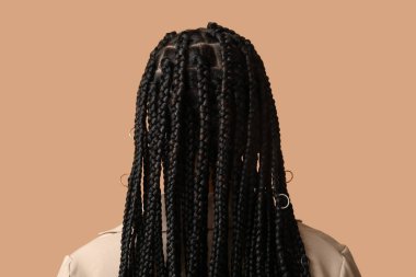 Bej arka planda örgü ören Afro-Amerikan bir kadın.