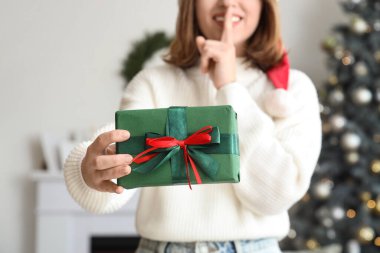 Evde Noel hediyesi kutusu olan genç bir kadın, yakın plan.