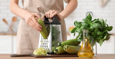 Mutfakta taze kabak rendeleyen bir kadın.