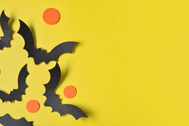 Sarı arka planda Cadılar Bayramı partisi için kağıt yarasalar