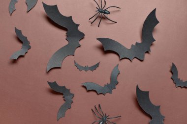 Kahverengi arka planda Cadılar Bayramı partisi için kağıt yarasalar ve örümcekler