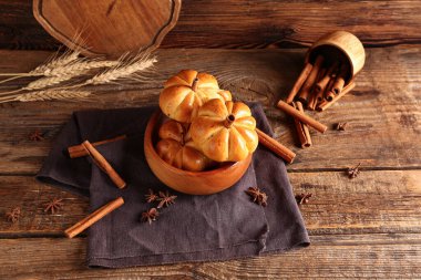 Ahşap arka planda lezzetli balkabağı şekilli çörekler.