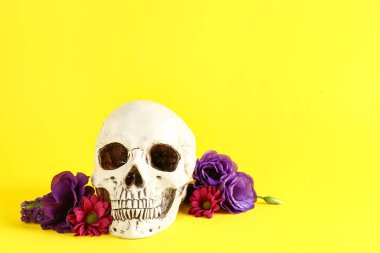 Sarı arka planda güzel çiçekli insan kafatası