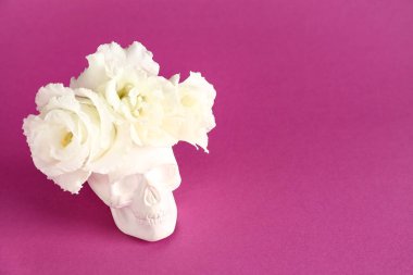 Morarmış arka planda güzel Eustoma çiçekleri olan insan kafatası.