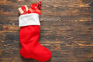 Noel çorabı hediye kutuları ve ahşap arka planda Rowan.