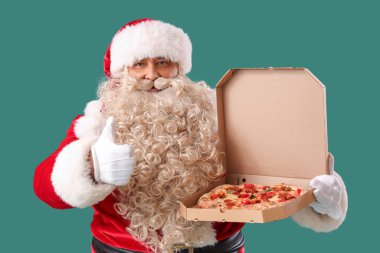 Lezzetli pizzalı Noel Baba yeşil arka planda baş parmağını gösteriyor.